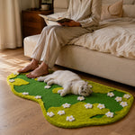 Cat relaxing on the garden meadow scratching rug beside a bed