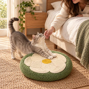 Cat stretching on the sage flower scratcher beside the bed