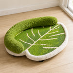 Green leaf-shaped cat scratcher bed with soft curved bolster